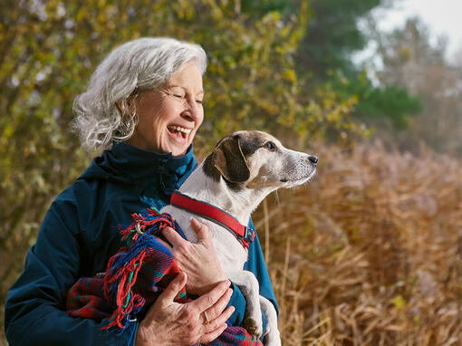 Femme tenant un chien dans une couverture à l'extérieur